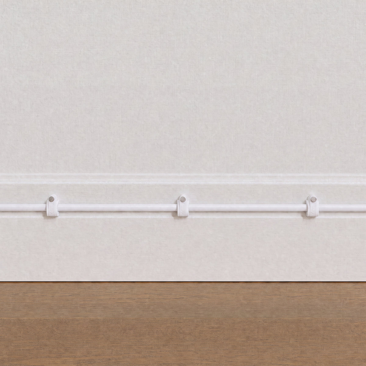 QualGear 4 mm cable clips in white routing a cable along a light wall above a wood floor