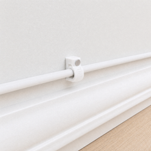QualGear 7 mm cable clip in white holding a white cable flush along a light wall