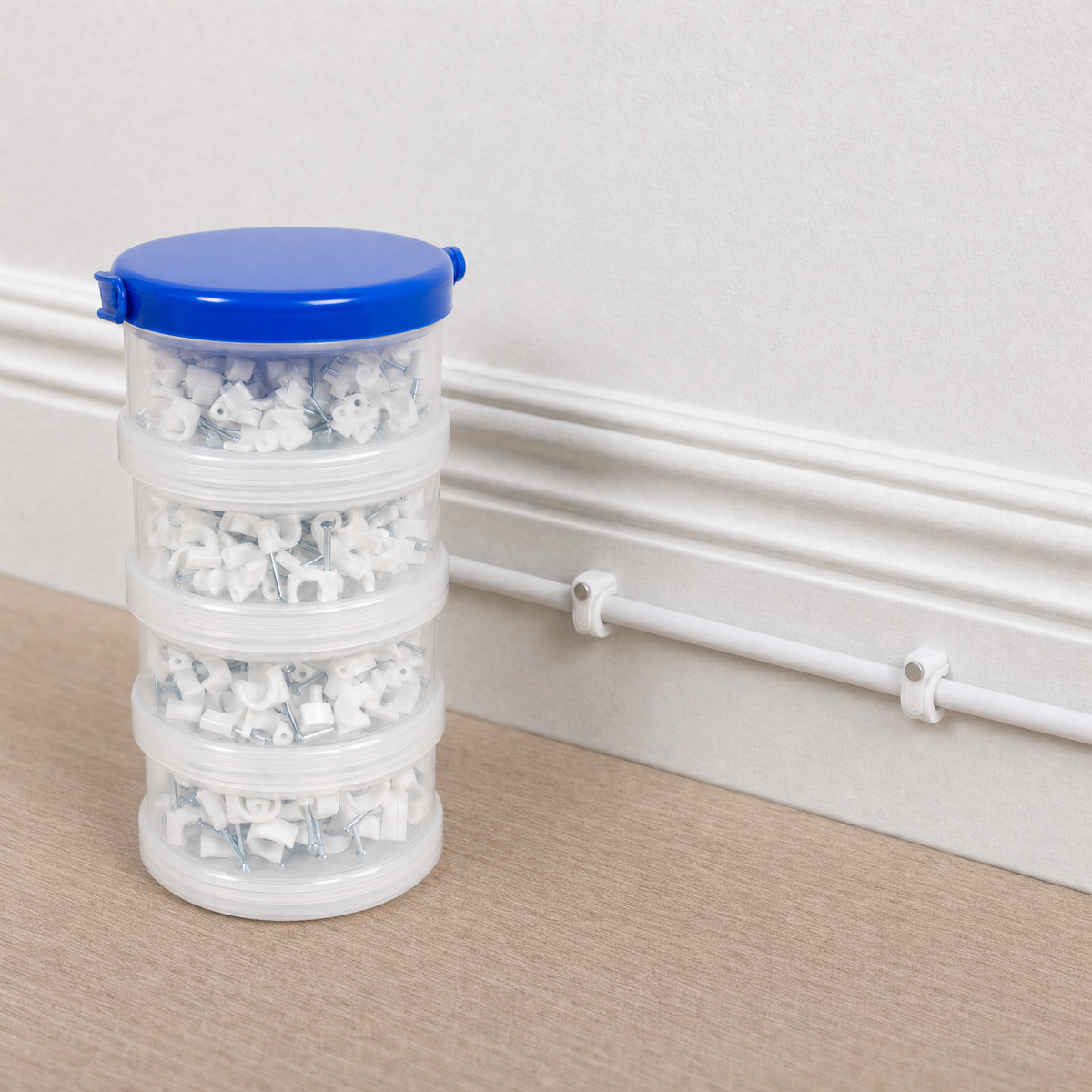 QualGear 400-pack cable clip canister in white (6, 7, 8, 10 mm) beside clips mounted on a white wall