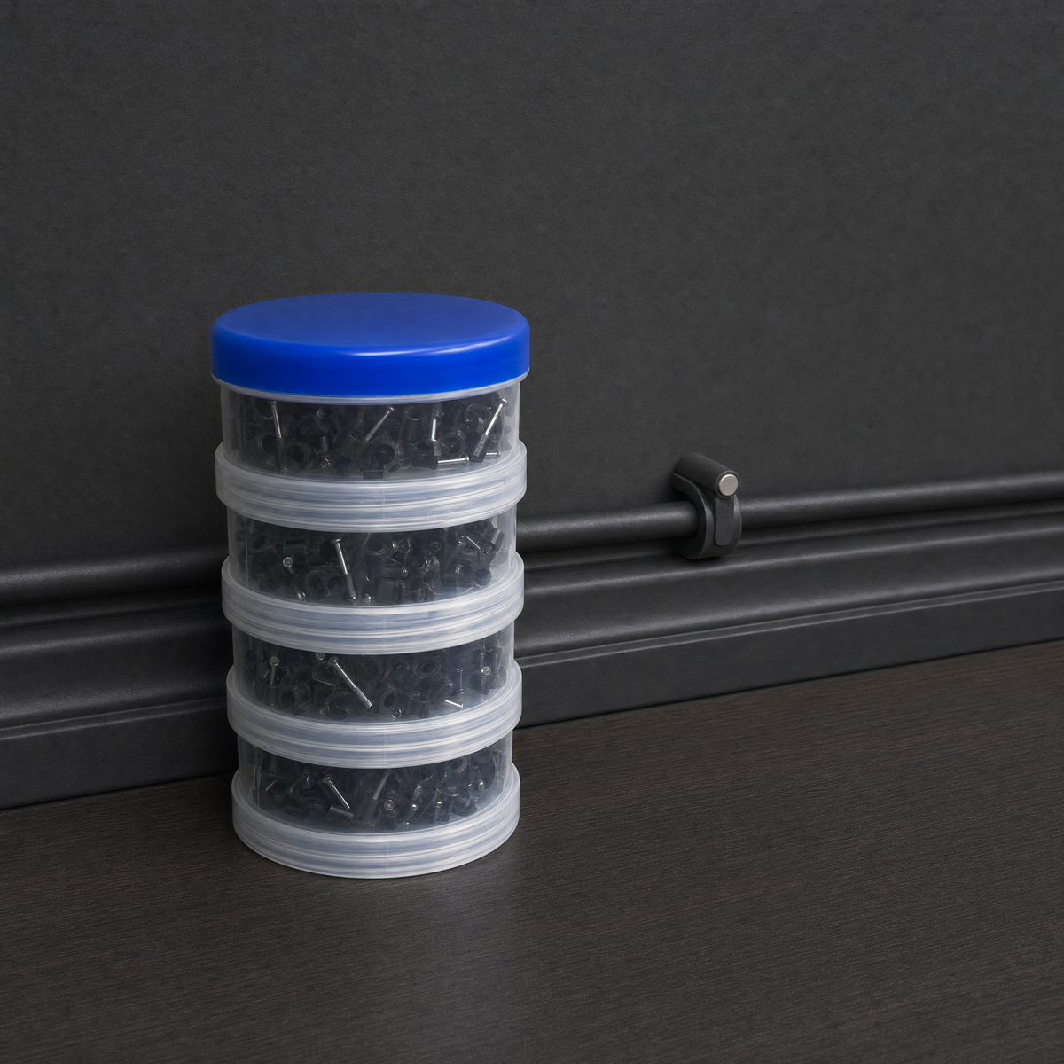 QualGear 400-pack cable clip canister in black (6, 7, 8, 10 mm) beside clips mounted on a black wall