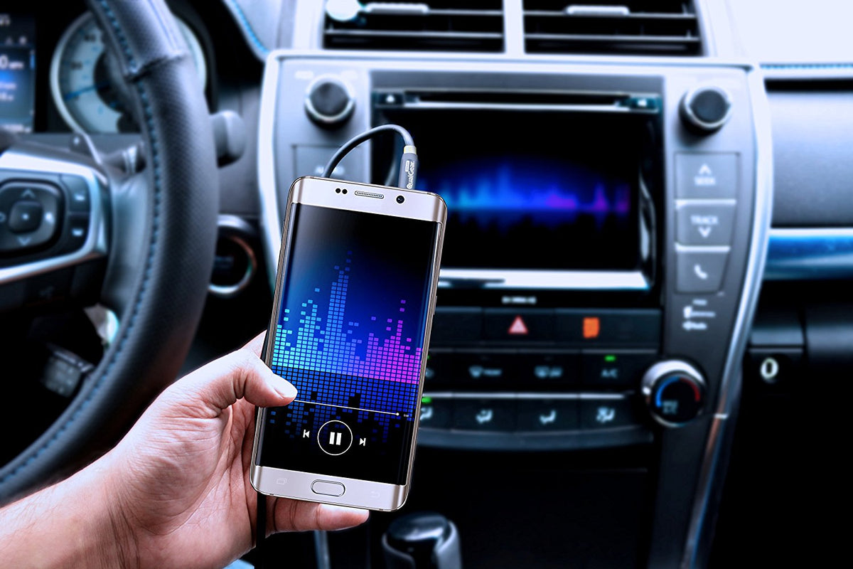 QualGear aux audio cable connecting a smartphone to a car stereo