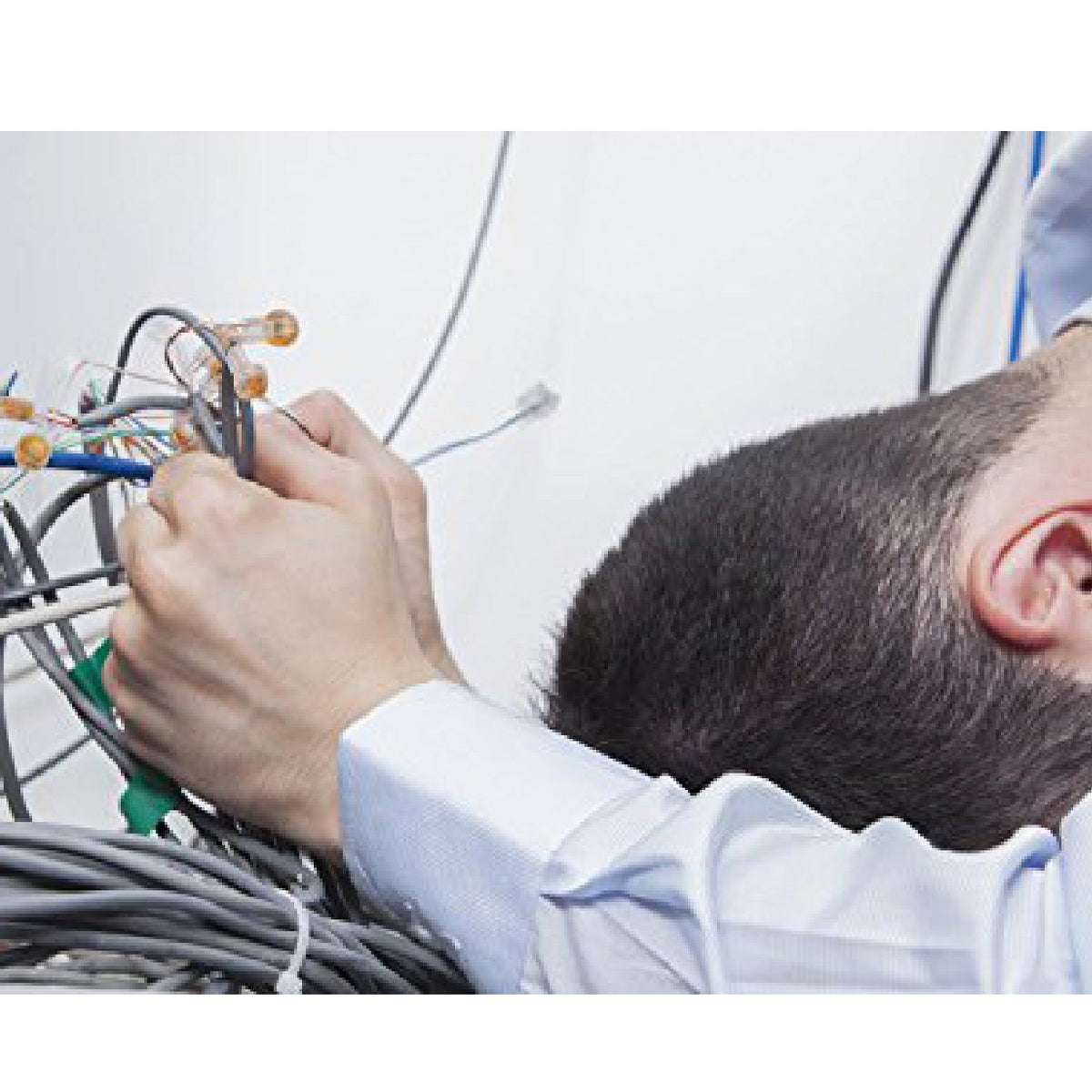 Technician gathering loose network cables by hand before tying them off
